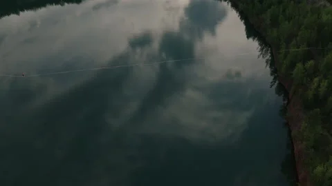 Slackline balanced walk over large chasm of pristine water and woods. High 5 Stock Footage 158403005