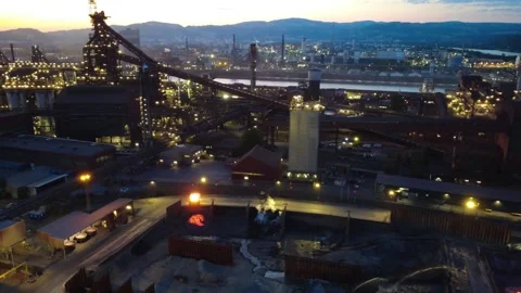 A slag pot carrier tips molten slag into a pit at a steelworks during blue hour Video stock 342728868
