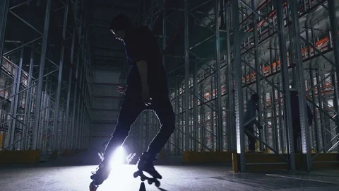 Slalom on a roller in a logistics center in backlight Video stock 104307077