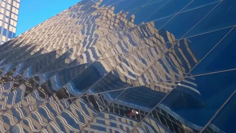 The slanted glass surface of one building reflects the surrounding skyscrapers Stock-Footage 333417542