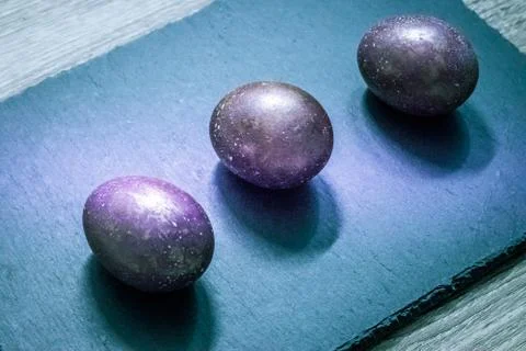 Slate cutting board with Easter cosmic space colored eggs Stock Photos