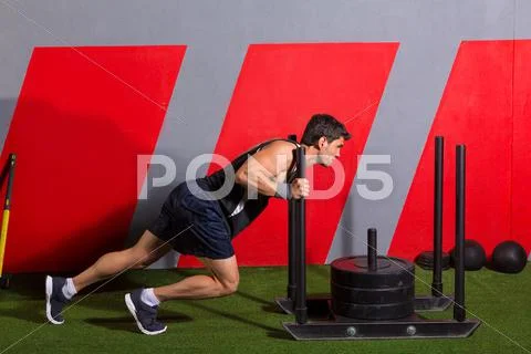 Sled push man pushing weights workout exercise Stock Photos