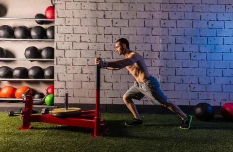 Sled push man pushing weights workout Stock Photos