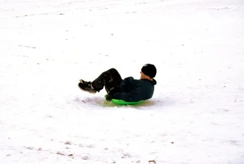 Sledding down the hill 写真素材