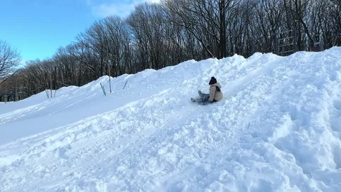 Sledding in winter park, snow weather. Child slides down. Children ski  Stock Footage 288401481