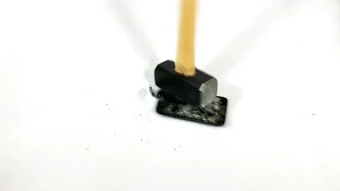 Sledgehammer falls vertically onto a smartphone coming to rest beside Video stock 150268240