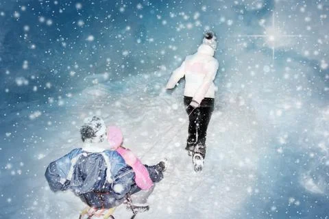 Sledges with children attached pulled on snow by woman in the winter Stock Photos