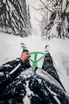 Sledging down the hill over snowy forest. First person view. Point of view, s Stock Photos