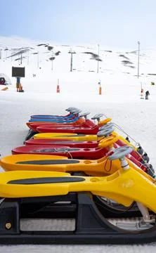 Sleds lined up against the backdrop of a ski slope Stock Photos