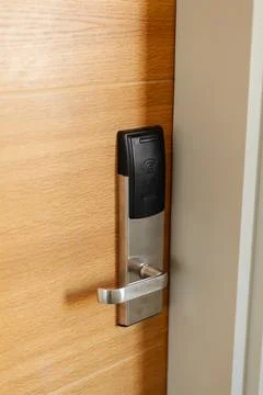 A sleek electronic door lock is installed on a wooden door, showcasing modern Stock Photos