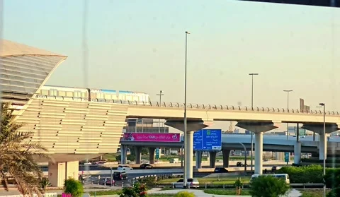 A sleek, elevated Dubai Metro train glides past modern architecture Video stock 311884188