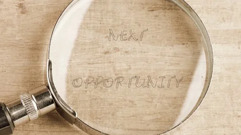 Sleek magnifying glass clarifies next opportunity on wood, revealing a guiding Stock Footage 332055585