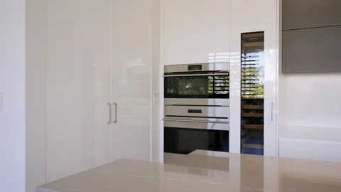 Sleek minimalist kitchen with clean lines and monochromatic color scheme and Stock Footage 262265676