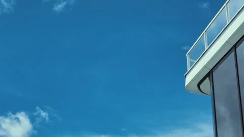 A sleek modern building corner viewed from below with a clear blue sky in the Stock Footage 338164971