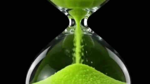 A sleek, modern hourglass featuring glowing green sand flowing steadily Stock Footage 340318415