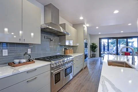 Sleek modern kitchen design with a kitchen peninsula, glossy gray backsplash, Stock Photos