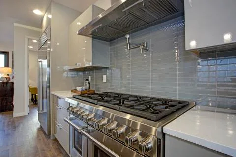 Sleek modern kitchen design with a kitchen peninsula, glossy gray backsplash, Foto stock
