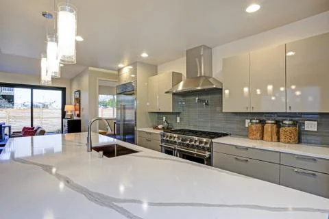 Sleek modern kitchen design with a kitchen peninsula fitted with a gray and w Stock Photos