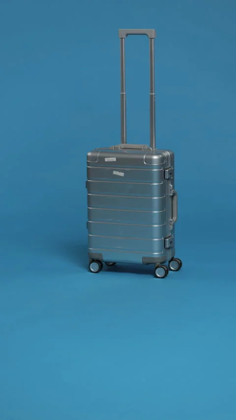 A sleek silver suitcase with an extended handle, ready for travel. Stock Footage 276949931