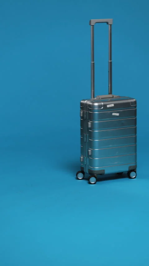 A sleek silver suitcase with an extended handle, ready for travel. Stock Footage 276950168