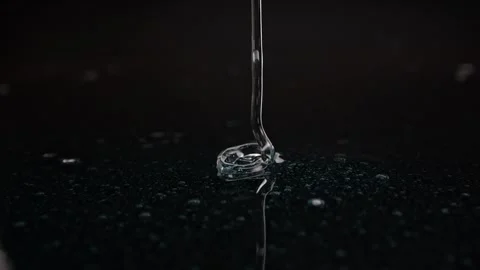 Sleek, slightly blue gel making contact with a dark surface, perfect for po.. Stock-Footage 263027725