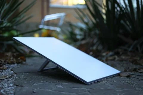 Sleek Solar Panel Positioned Elegantly on a Stone Surface in an Inviting Natural Stock Photos