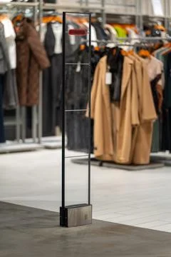 A sleek, transparent security gate stands at the entrance of a modern clothin Fotos de archivo