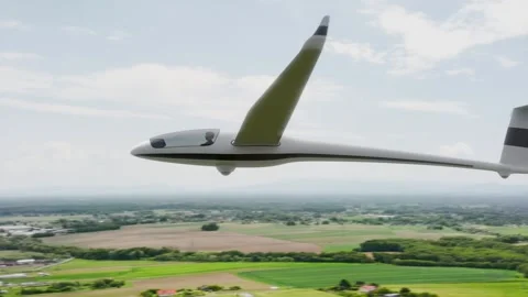 A sleek, white glider soars gracefully over a picturesque landscape beneath.. 스톡 동영상 310620580
