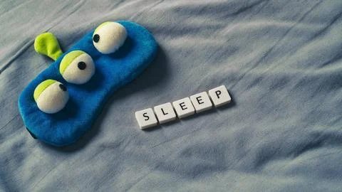 Sleep concept with sleeping mask on a soft bed sheet. Copy space for text Stock Photos