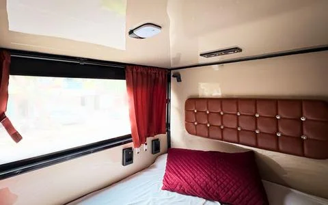 Sleeper Bus Interior With Comfortable Berth Bedding and Window Curtains Stock Photos