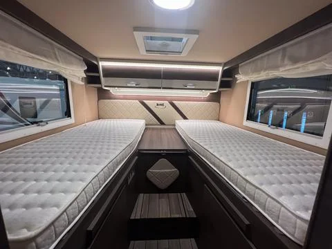 Sleeping area inside camper van with twin beds Фото