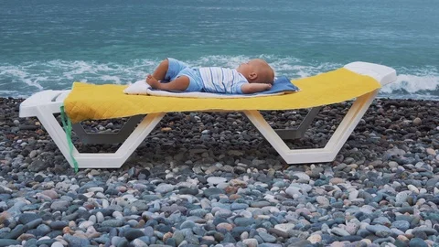 The sleeping baby on the beach Видео 86462690