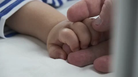 Sleeping baby's hand stroking his father's hand Stock Footage 149235059