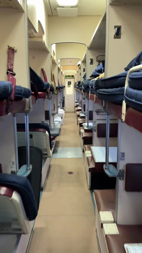 Sleeping berths in a second-class train carriage with neatly arranged bedding Video stock 302471544