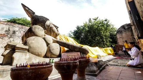 Sleeping buddha statue with buddhist come to pay respect. Stock Photos