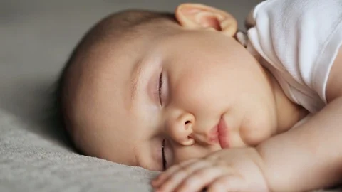 Sleeping cute baby boy on gray blanket 스톡 동영상 128002845