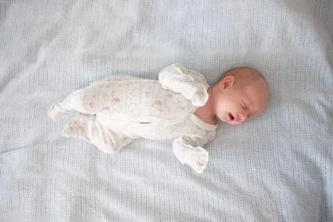 A sleeping cute newborn in a small bed Stock Photos