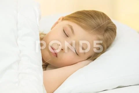The sleeping girl lay on the bed Stock Photos