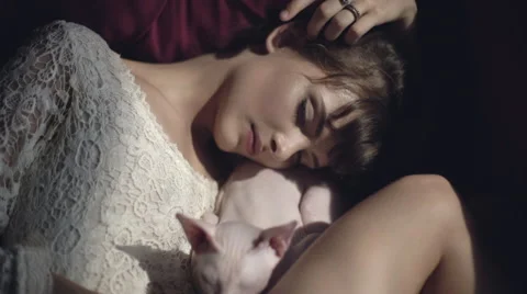 Sleeping girl with a sphinx cat Stock Footage 66782881