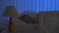 The sleeping girl turn on the lamp. Evening night time 4k or 4k+ Resolution