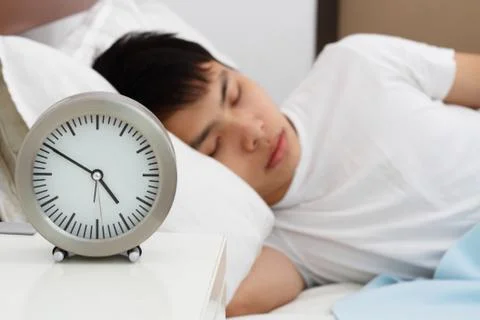 Sleeping man with clock Stock Photos