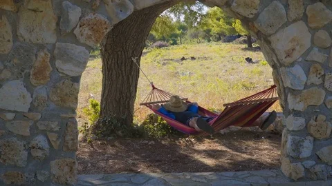 Sleeping man on old fashioned vintage hammock in the garden Video stock 77265849
