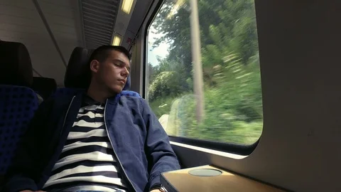 Sleeping passenger reasting while traveling with a train, eyes closed Stock Footage 106596446