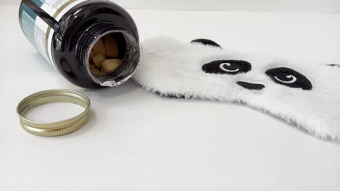 Sleeping pills and a cute panda eye mask on a white background, representin.. Vídeos de archivo 335141490