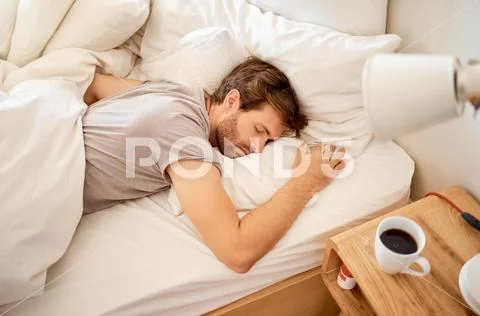 Sleeping resting and sleepy man lying in bed with his eyes closed