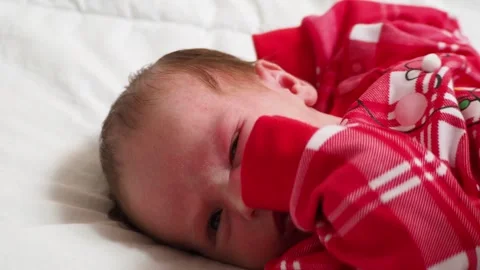 Sleeping, two week old, newborn, baby boy wearing a crocheted Santa hat wit.. Stock Footage 293731814