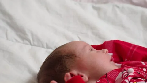Sleeping, two week old, newborn, baby boy wearing a crocheted Santa hat wit.. Видео 293732011