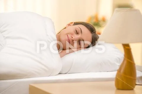 The sleeping woman on the background of a bedside table Stock Photos