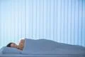 The sleeping woman lay on the bed. Evening night time Photo