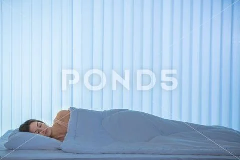The sleeping woman lay on the bed. Evening night time Stock Photos